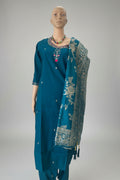 A teal blue ethnic salwar kameez suit displayed on a mannequin, featuring a heavily embroidered neckline with red and gold details, a matching printed dupatta, and small silver mirror work.